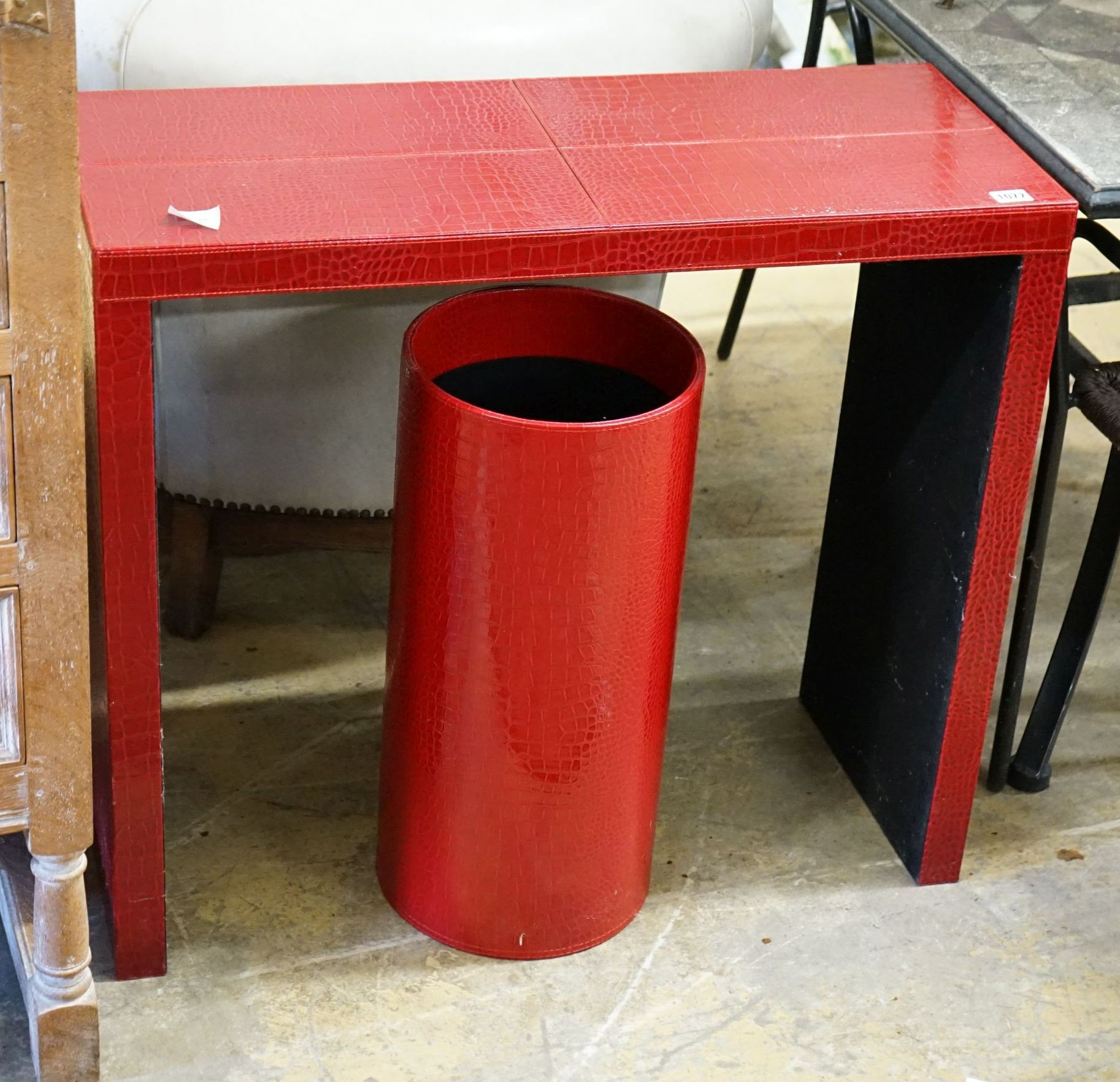 A contemporary red faux crocodile console table, width 80cm, depth 32cm, height 70cm and a stick stand